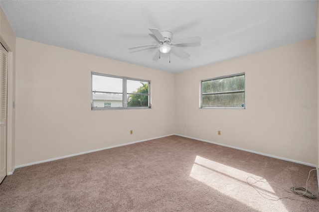 spare room featuring carpet flooring, a textured ceiling, and ceiling fan