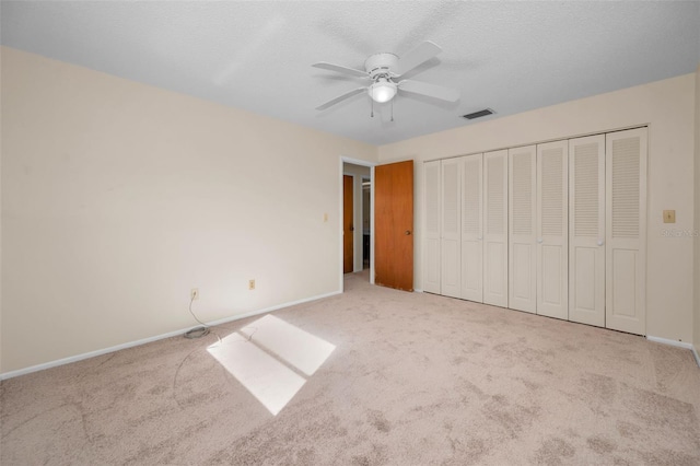 unfurnished bedroom with light carpet, a closet, and ceiling fan