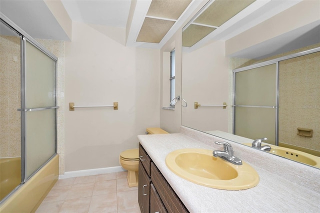 full bathroom with tile patterned floors, vanity, toilet, and bath / shower combo with glass door