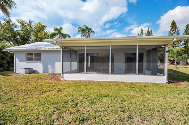 back of property with a sunroom and a yard