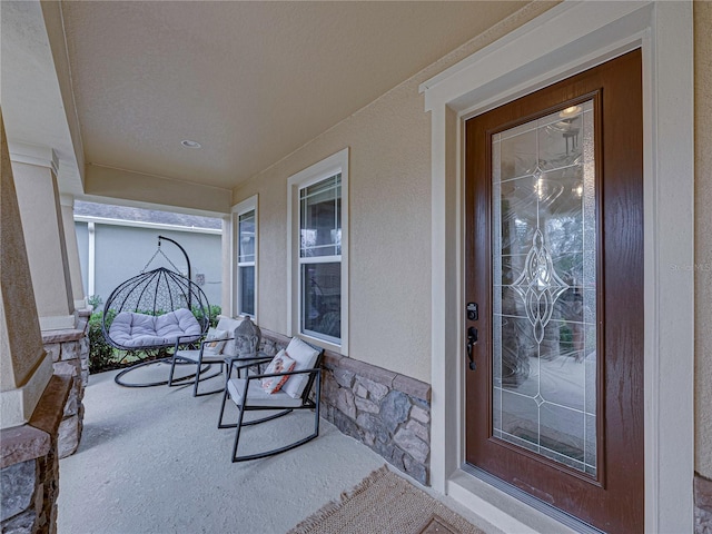 view of exterior entry featuring covered porch