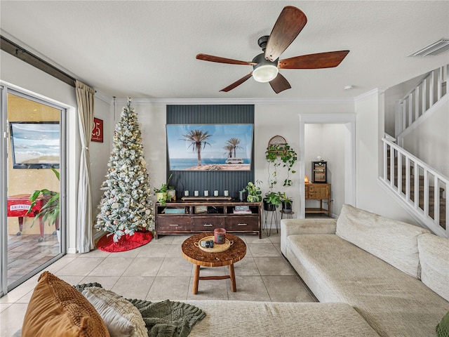 living room with light tile patterned floors, a textured ceiling, and ornamental molding