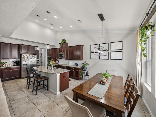 tiled dining area featuring a textured ceiling, vaulted ceiling, crown molding, sink, and a chandelier