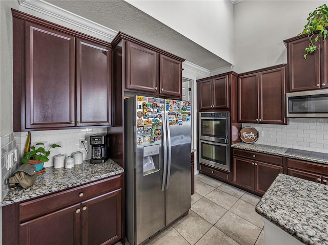 kitchen featuring decorative backsplash, light stone counters, light tile patterned floors, and stainless steel appliances