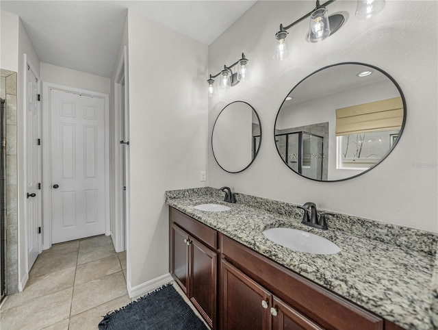 bathroom featuring tile patterned floors, vanity, and a shower with shower door