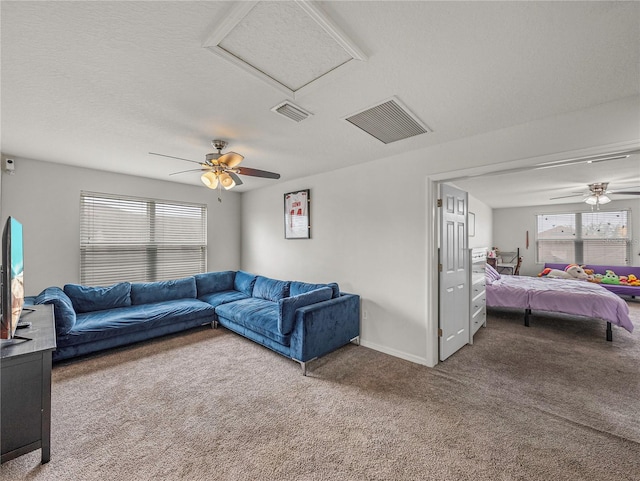 living room with ceiling fan, carpet floors, and a textured ceiling