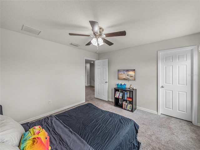 carpeted bedroom featuring ceiling fan and a textured ceiling