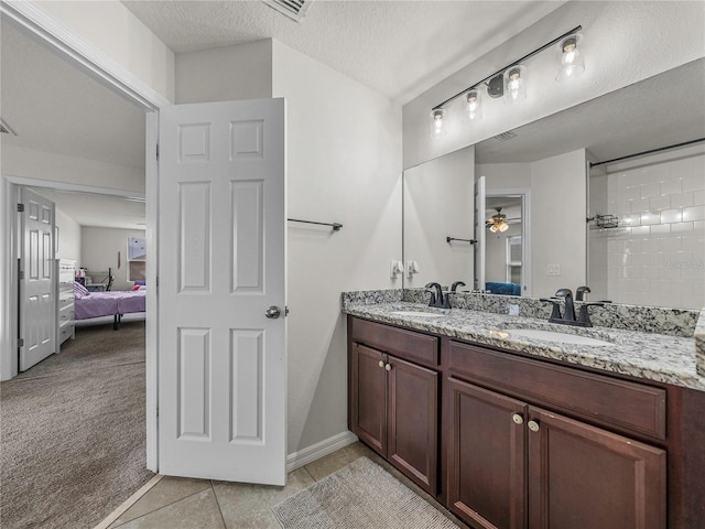 bathroom featuring tile patterned floors, vanity, ceiling fan, and a textured ceiling