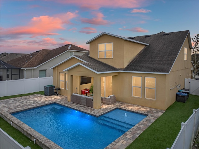 back house at dusk featuring a fenced in pool, a patio area, an outdoor living space, and central AC unit