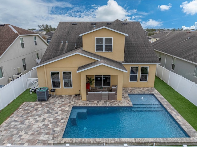 back of house featuring a fenced in pool, central air condition unit, and a patio