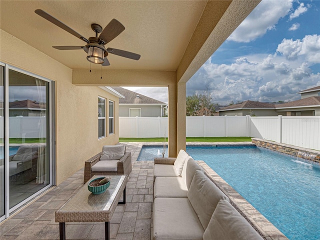 view of pool with outdoor lounge area, pool water feature, a patio area, and ceiling fan