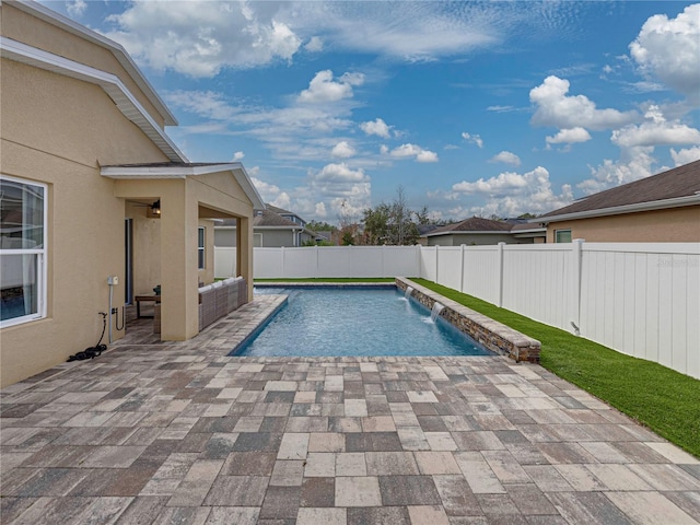 view of swimming pool featuring pool water feature and a patio