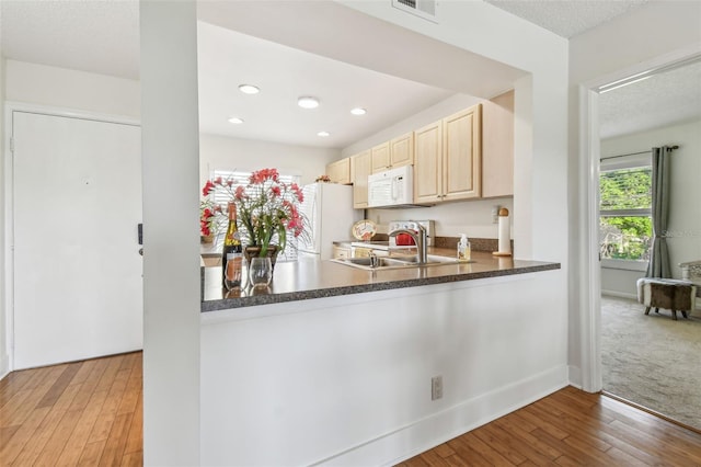 kitchen with white appliances, sink, and light wood-type flooring