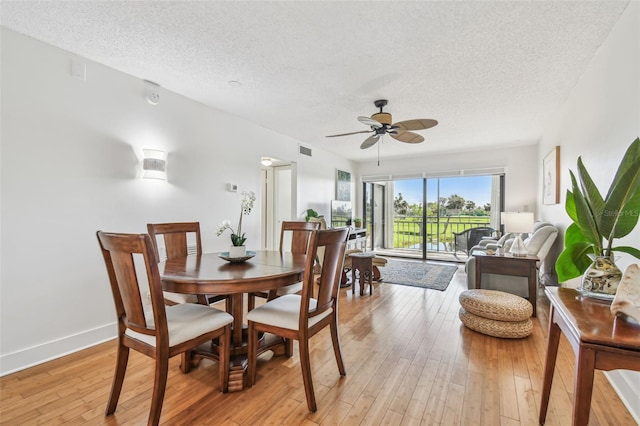 dining room with a textured ceiling, ceiling fan, and light hardwood / wood-style flooring