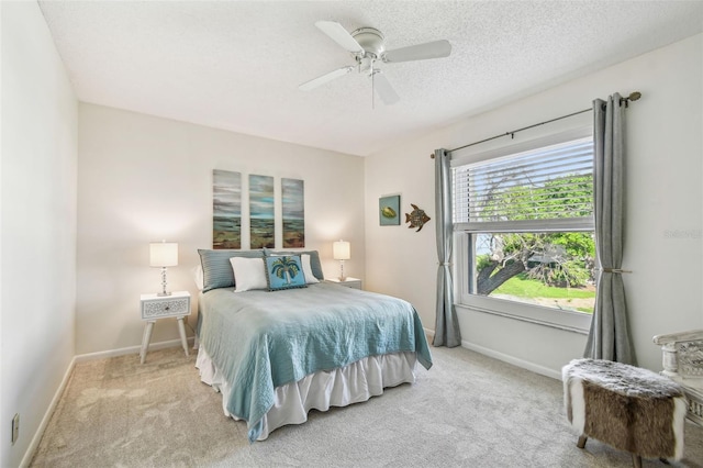 carpeted bedroom with ceiling fan and a textured ceiling