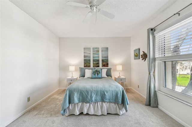 bedroom with light colored carpet, a textured ceiling, and ceiling fan