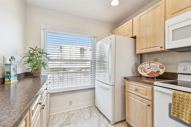 kitchen with light brown cabinetry and white appliances