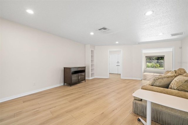 living room featuring a textured ceiling and light wood-type flooring