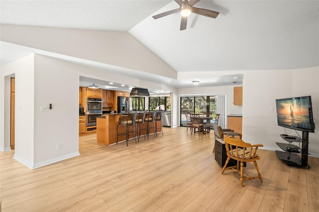 living room with ceiling fan, high vaulted ceiling, and light hardwood / wood-style flooring