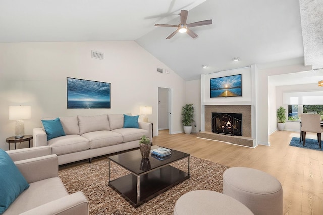 living room featuring ceiling fan, high vaulted ceiling, and light wood-type flooring