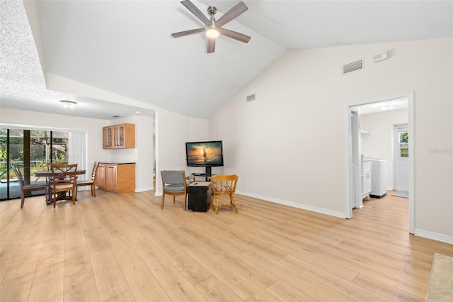 living area featuring ceiling fan, light hardwood / wood-style floors, lofted ceiling, and a textured ceiling