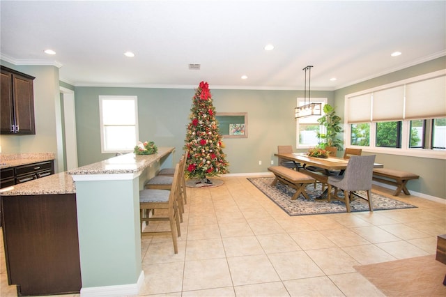 tiled dining area with plenty of natural light and ornamental molding