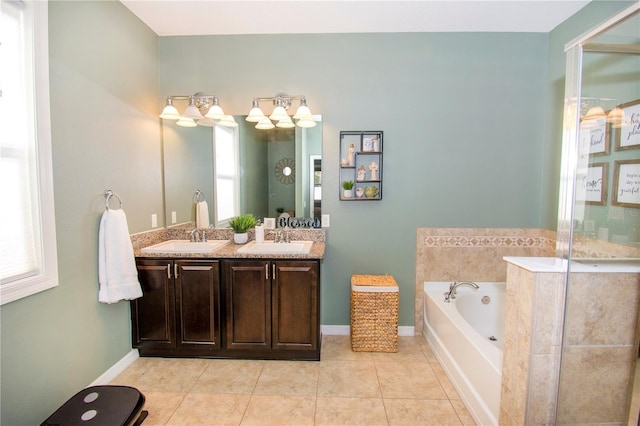 bathroom featuring tile patterned floors, vanity, a healthy amount of sunlight, and a tub