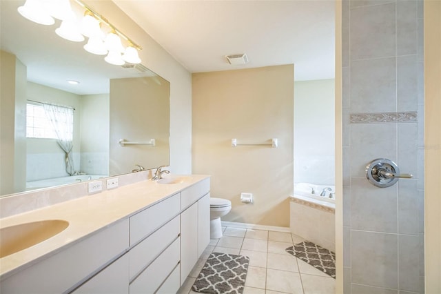 bathroom with tiled bath, tile patterned flooring, vanity, and toilet