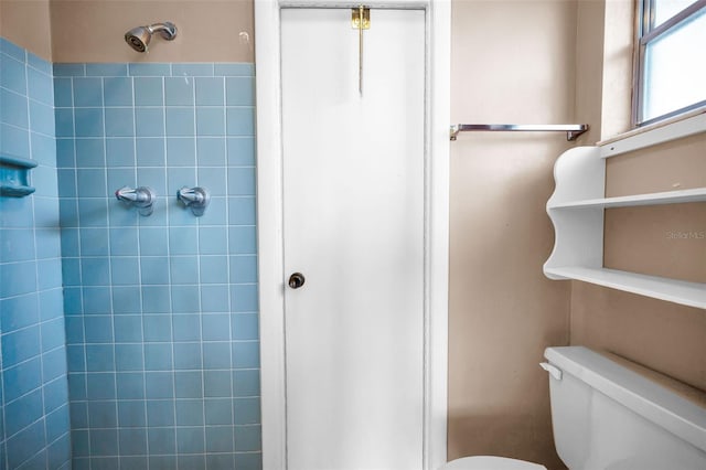 bathroom with tiled shower and toilet