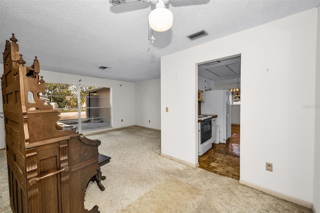 office featuring a textured ceiling, ceiling fan, and light parquet flooring