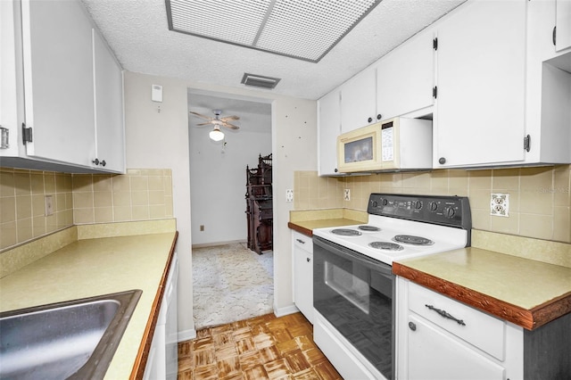 kitchen featuring white appliances, ceiling fan, sink, white cabinets, and light parquet flooring