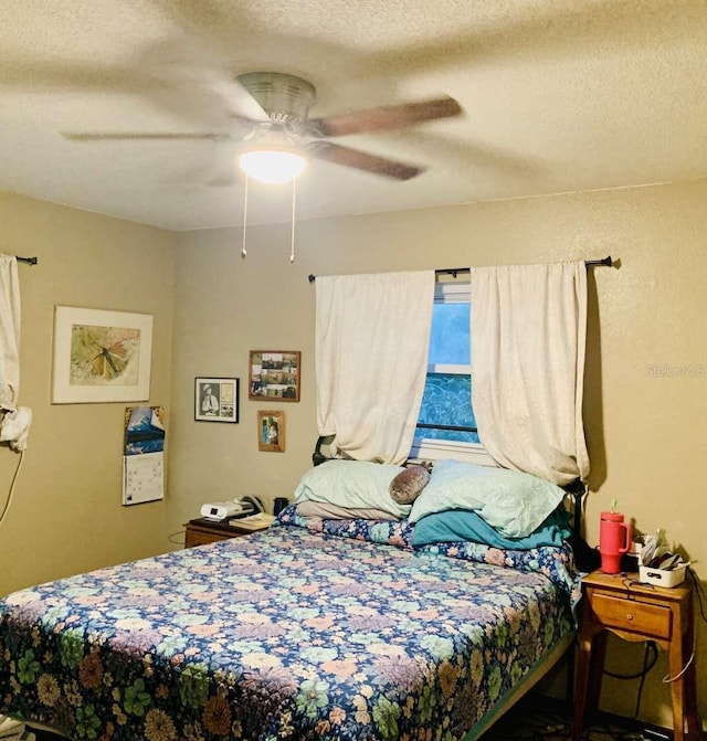 bedroom with ceiling fan and a textured ceiling