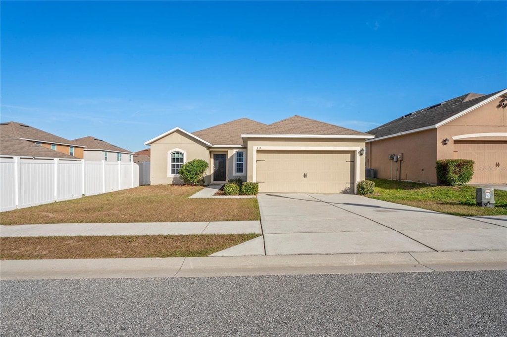 single story home featuring a garage and a front lawn