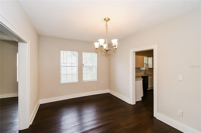 unfurnished dining area featuring a chandelier, dark wood-type flooring, and sink