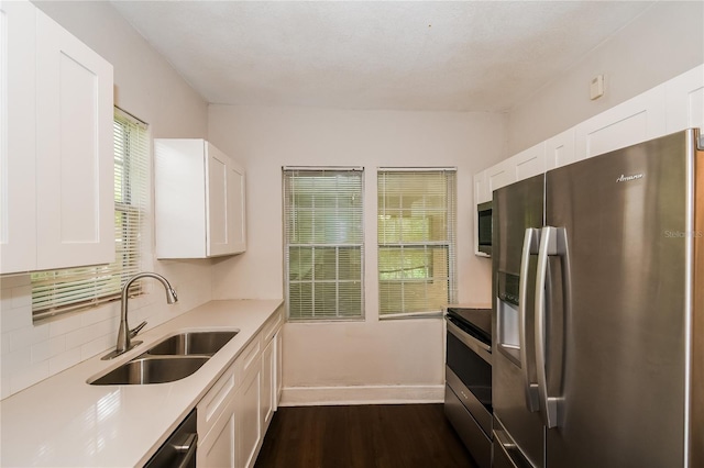 kitchen with sink, dark hardwood / wood-style floors, a wealth of natural light, appliances with stainless steel finishes, and white cabinetry