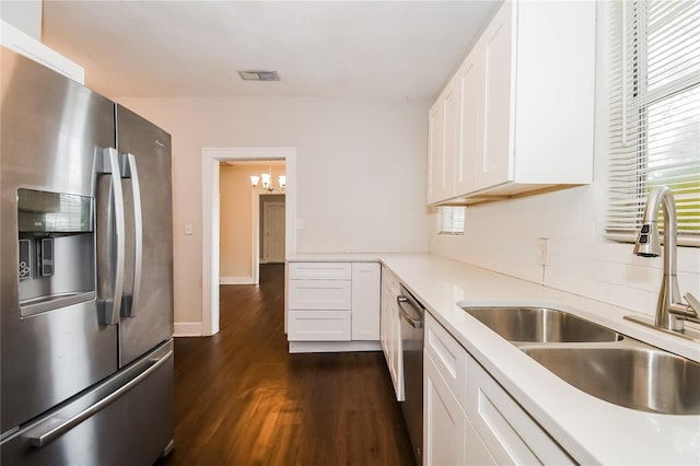 kitchen featuring dark wood-type flooring, white cabinets, sink, decorative backsplash, and stainless steel appliances