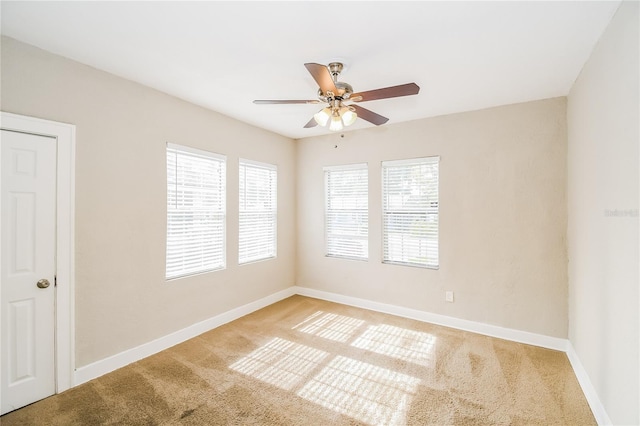 carpeted spare room featuring ceiling fan