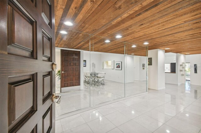 foyer with light tile patterned flooring and wood ceiling