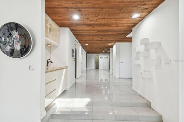 corridor with wooden ceiling, sink, and light tile patterned floors