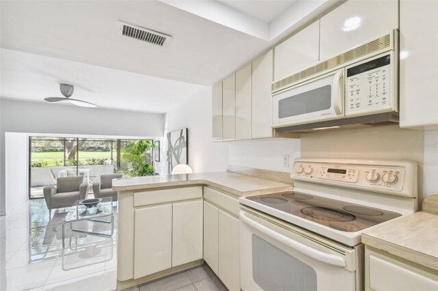 kitchen featuring light tile patterned flooring, white appliances, and kitchen peninsula