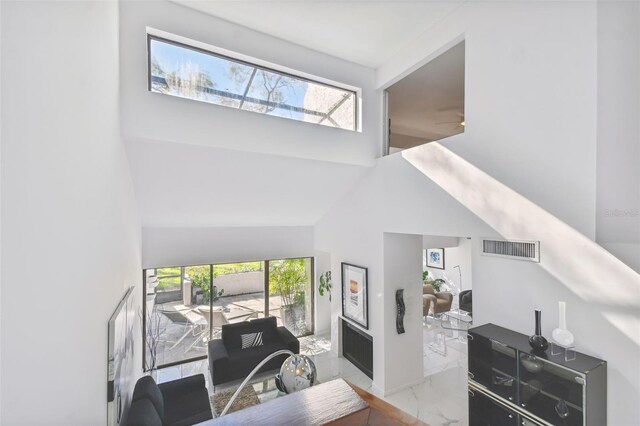 living room with high vaulted ceiling and a wealth of natural light