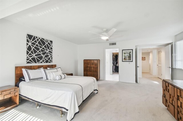 bedroom with a closet, light colored carpet, and ceiling fan