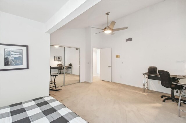 carpeted bedroom featuring ceiling fan, a closet, and high vaulted ceiling