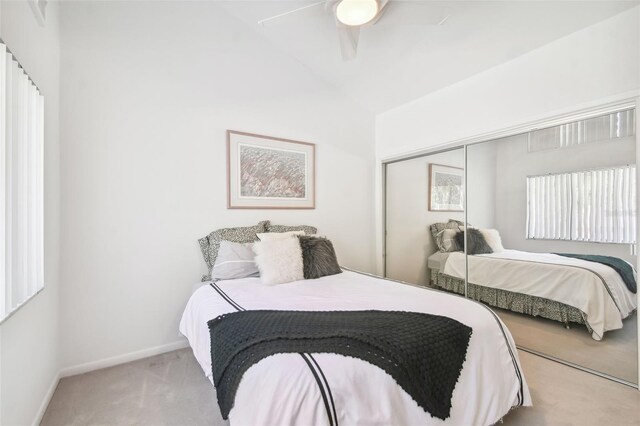 bedroom with ceiling fan, a closet, and light carpet