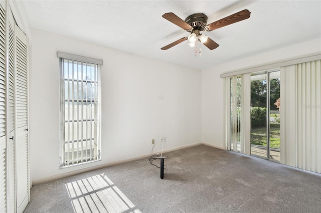 carpeted spare room featuring ceiling fan