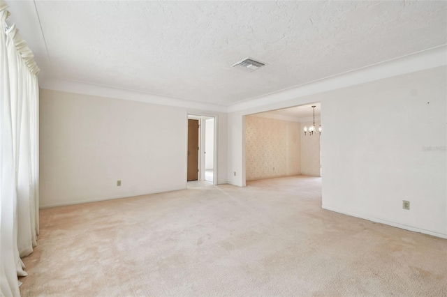 empty room featuring light carpet, a chandelier, and ornamental molding