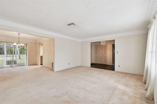 carpeted spare room with an inviting chandelier and crown molding