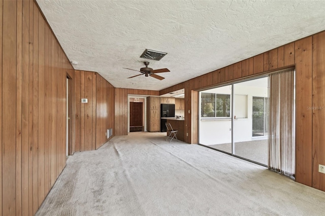 unfurnished living room with ceiling fan and light colored carpet