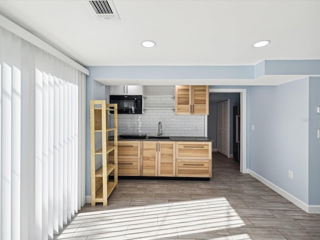 kitchen featuring decorative backsplash, light brown cabinets, and sink