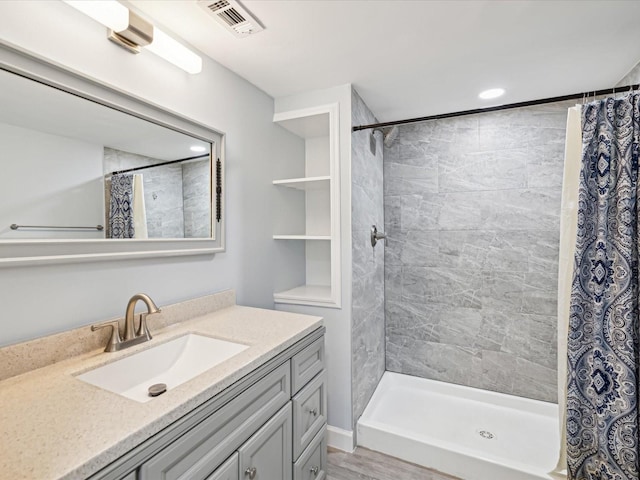 bathroom featuring vanity, wood-type flooring, and walk in shower